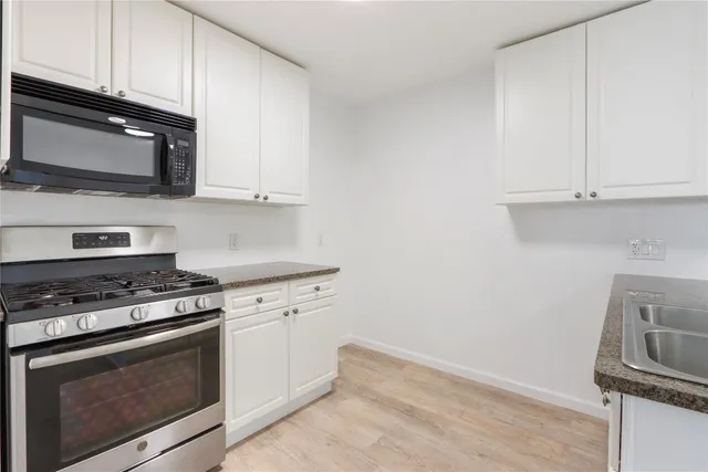 a kitchen with granite countertop cabinets stainless steel appliances and wooden cabinets