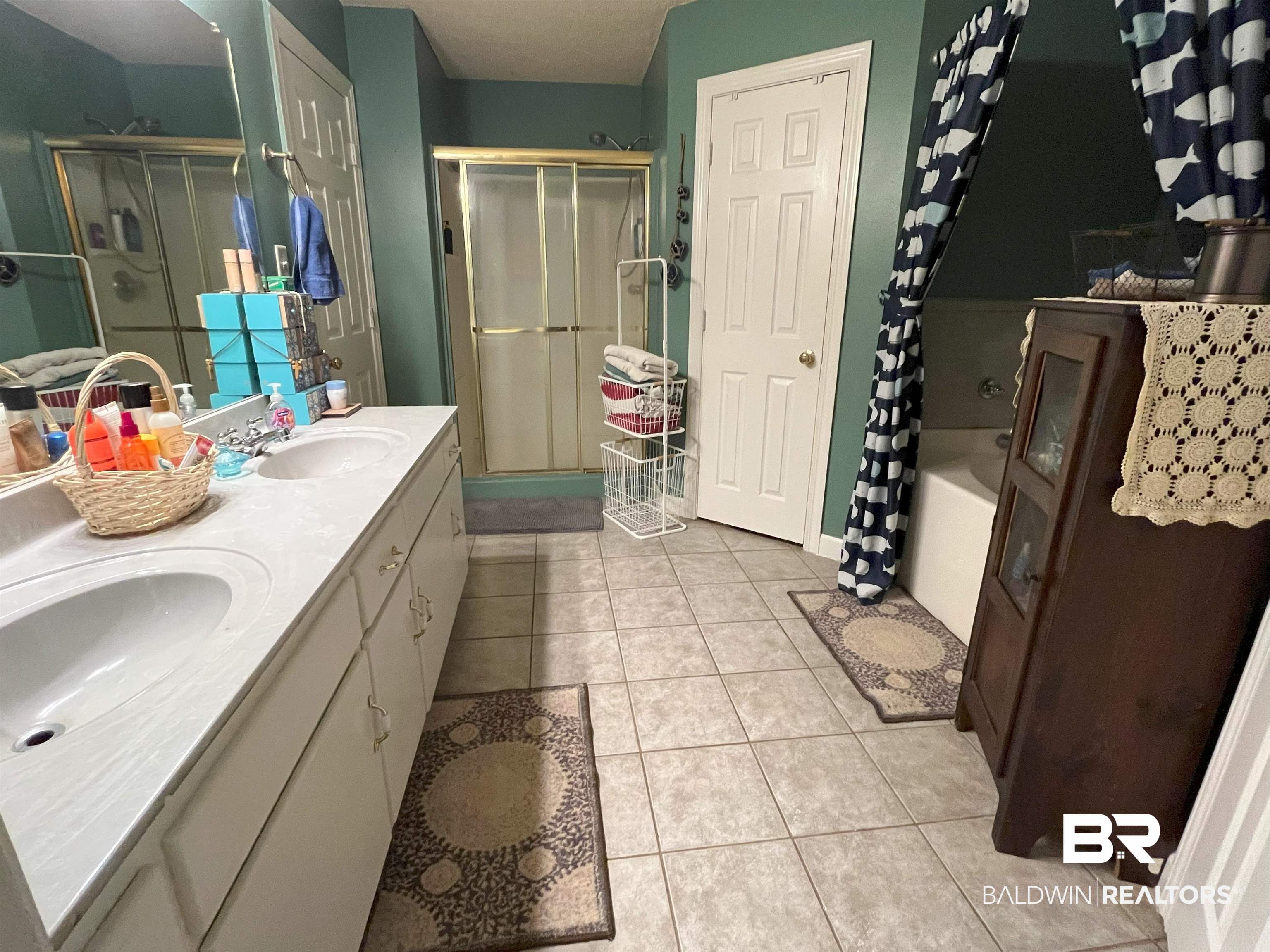 7851 Highway 98 Fairhope, AL 36532 - Photo 24 of 40 Bathroom with double vanity, light tile patterned floors, and shower with glass door