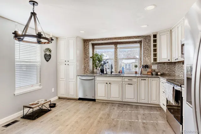 a kitchen with stainless steel appliances granite countertop a stove a sink and a refrigerator