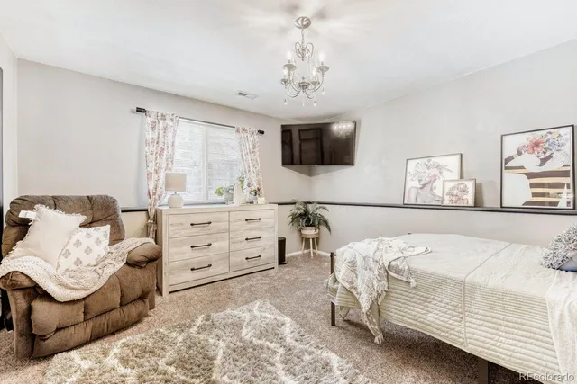 a bedroom with a bed a couch and a flat screen tv