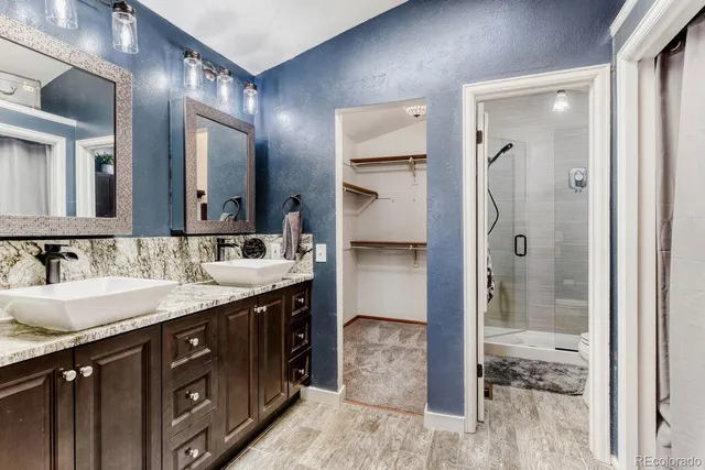 a bathroom with a granite countertop sink shower and a mirror