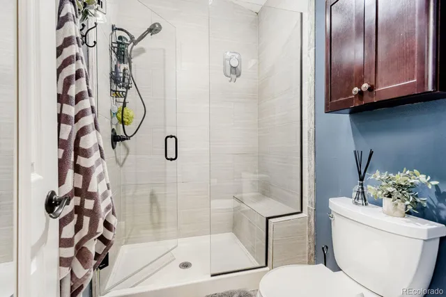 a bathroom with a shower a toilet and a shower