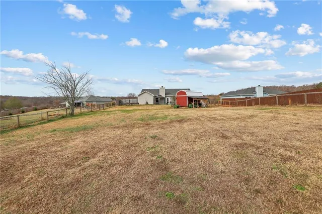 a view of a dry yard with wooden fence