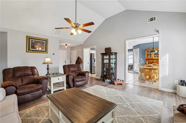 a living room with furniture a ceiling fan and a window