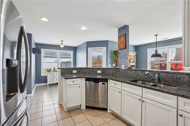 a kitchen with stainless steel appliances granite countertop a sink and a refrigerator
