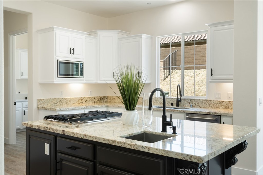 3086 Crystal Ridge Lane Colton, CA 92324 - Photo 11 of 71 a kitchen with kitchen island granite countertop a sink and white cabinets