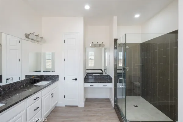 a bathroom with a tub sink double vanity and a mirror