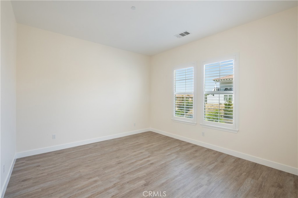 3086 Crystal Ridge Lane Colton, CA 92324 - Photo 39 of 71 a view of an empty room with wooden floor and a window