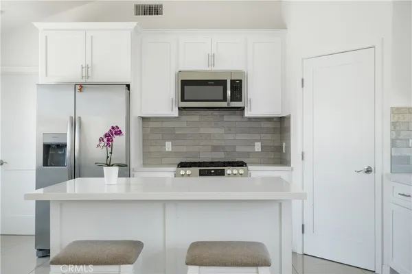 a kitchen with stainless steel appliances kitchen island granite countertop a stove and a sink with granite countertops