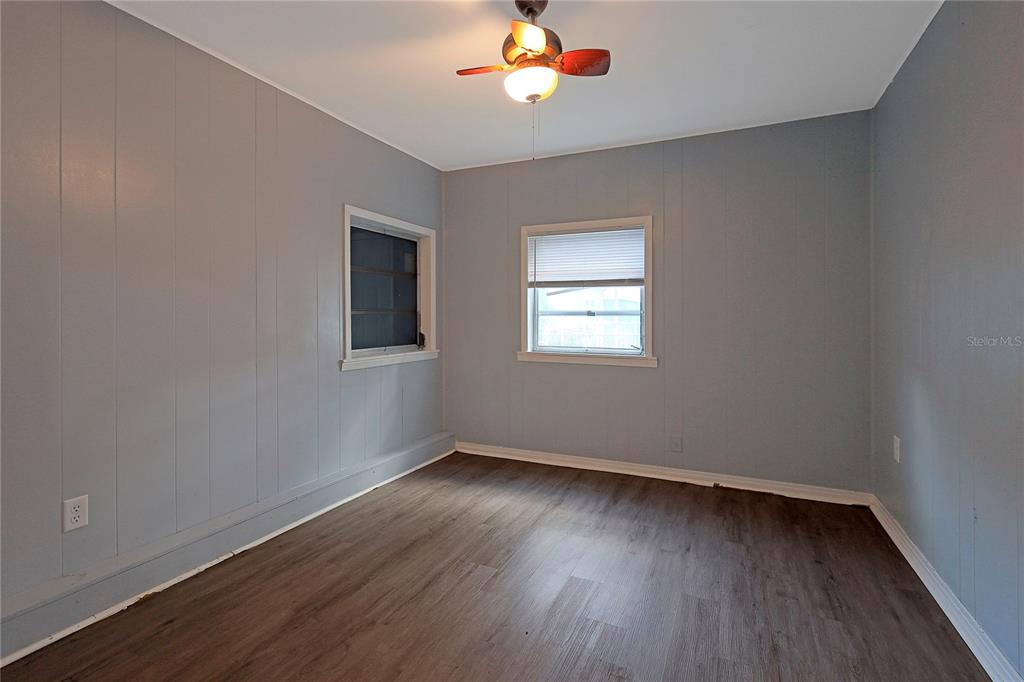 2011 East 148th Avenue Lutz, FL 33559 - Photo 19 of 37 an empty room with wooden floor chandelier fan and windows