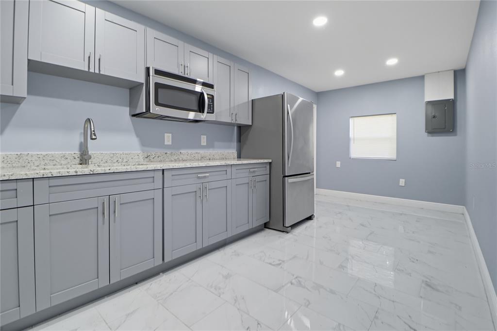 2011 East 148th Avenue Lutz, FL 33559 - Photo 28 of 37 a kitchen with stainless steel appliances granite countertop a refrigerator and a sink