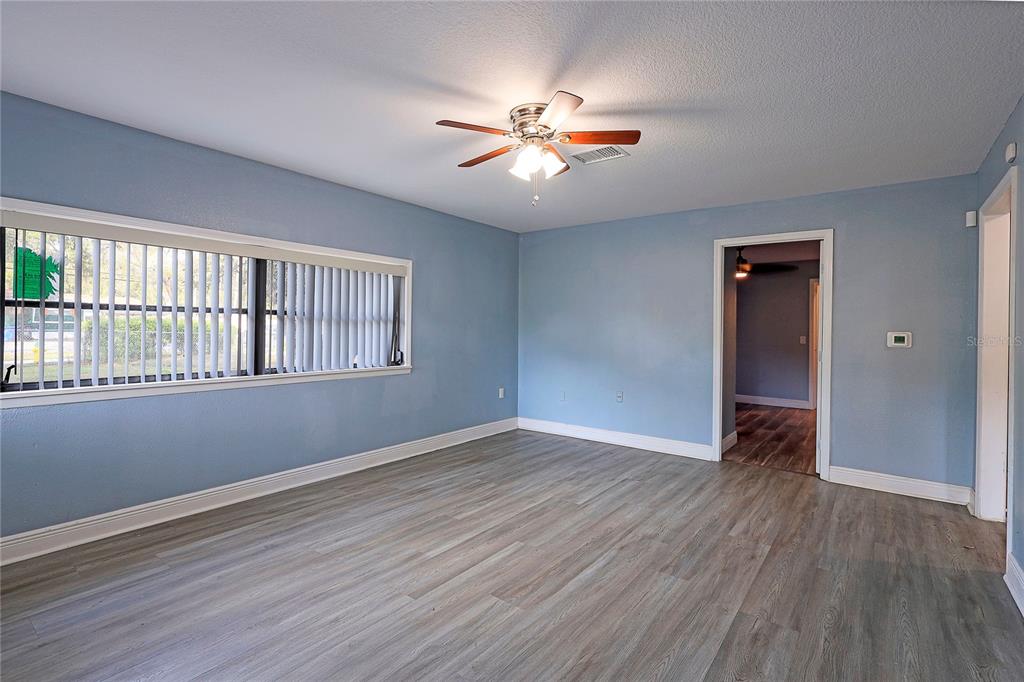 2011 East 148th Avenue Lutz, FL 33559 - Photo 3 of 37 a view of an empty room with wooden floor and a window