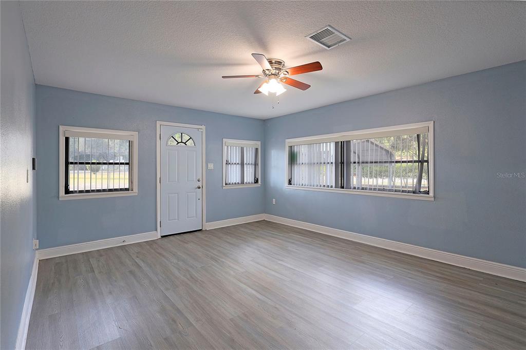 2011 East 148th Avenue Lutz, FL 33559 - Photo 4 of 37 a view of an empty room with a window and wooden floor