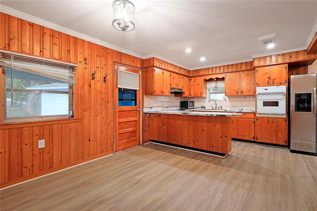 2011 East 148th Avenue Lutz, FL 33559 - Photo 7 of 37 a kitchen with stainless steel appliances granite countertop a refrigerator and wooden cabinets