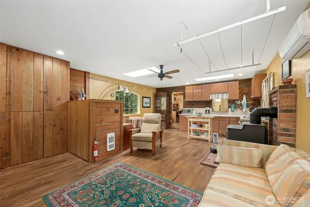 a living room with furniture a flat screen tv and kitchen view