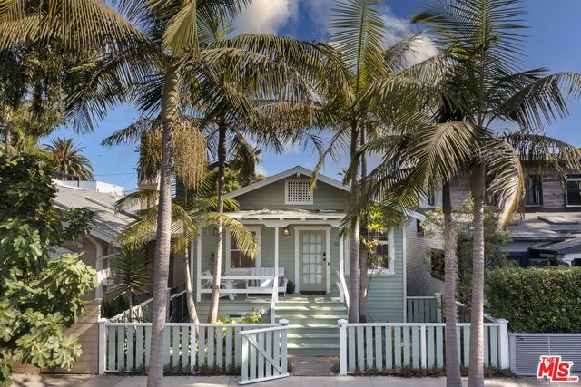 a front view of a house with a tree