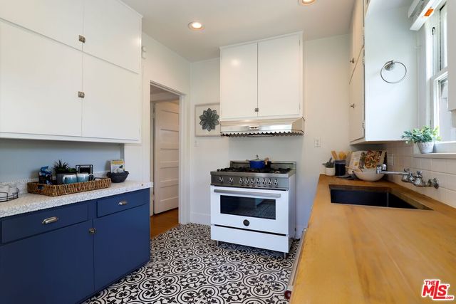 a kitchen with a sink a stove and cabinets