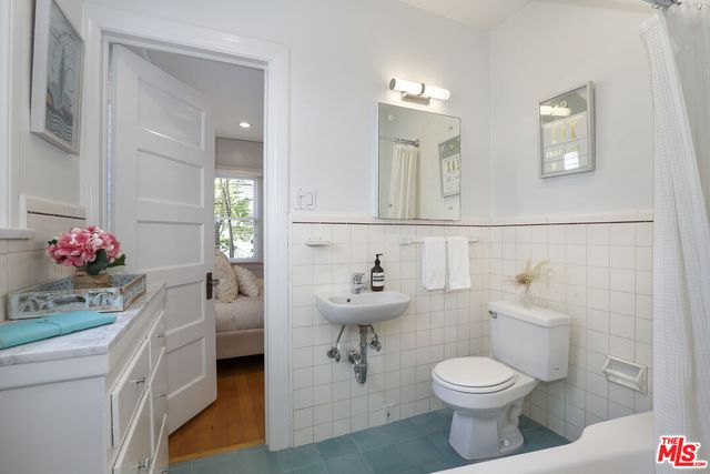 a bathroom with a sink a toilet and mirror