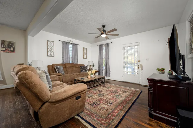 a living room with furniture a flat screen tv and a window