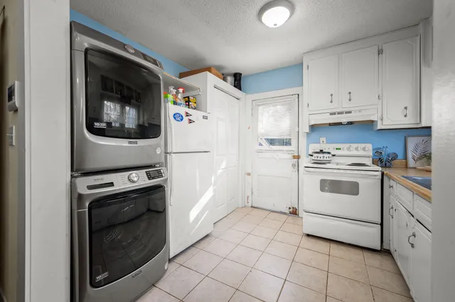 a kitchen with white cabinets and white appliances
