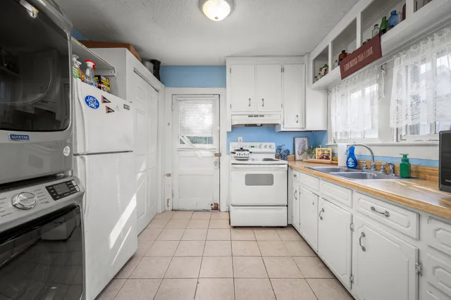 a kitchen with white cabinets and white appliances