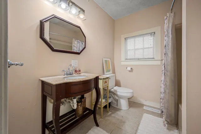 a bathroom with a toilet a sink and mirror