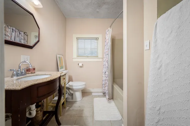 a bathroom with a toilet a sink and mirror