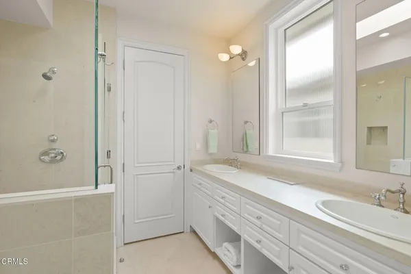 a spacious bathroom with a double vanity sink mirror and shower