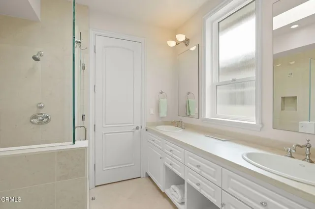 a spacious bathroom with a double vanity sink mirror and shower