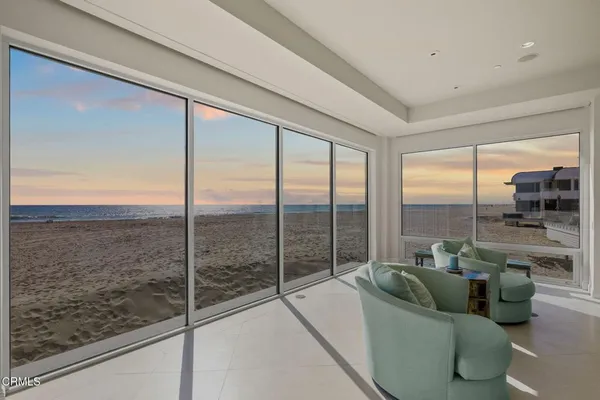 a living room with furniture a fireplace and floor to ceiling window