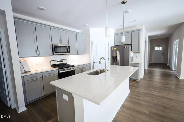 a kitchen with stainless steel appliances kitchen island a sink dishwasher a refrigerator and a stove