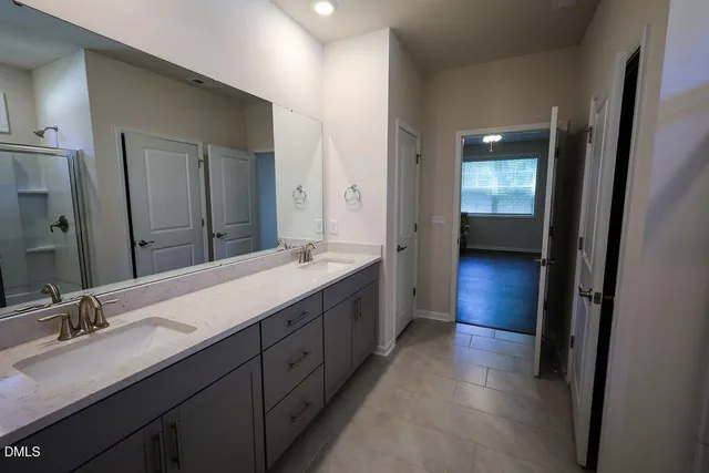 a spacious bathroom with a double vanity sink and mirror