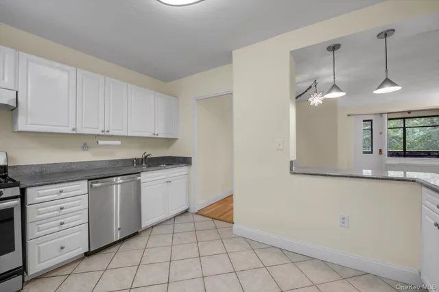 a kitchen with granite countertop white cabinets and white appliances