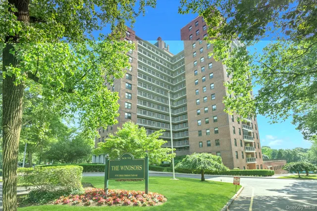 a view of a tall building next to a yard