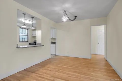 a view of a room with wooden floor and a ceiling fan