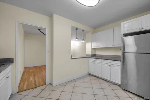a kitchen with granite countertop a sink and a refrigerator