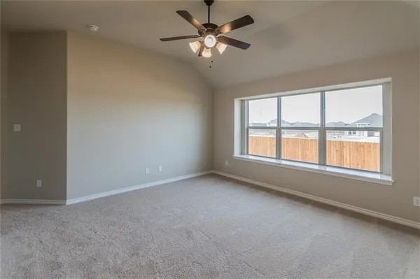 wooden floor in an empty room with a chandelier fan