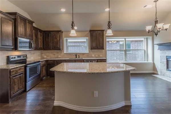 a kitchen with granite countertop a sink dishwasher and cabinets