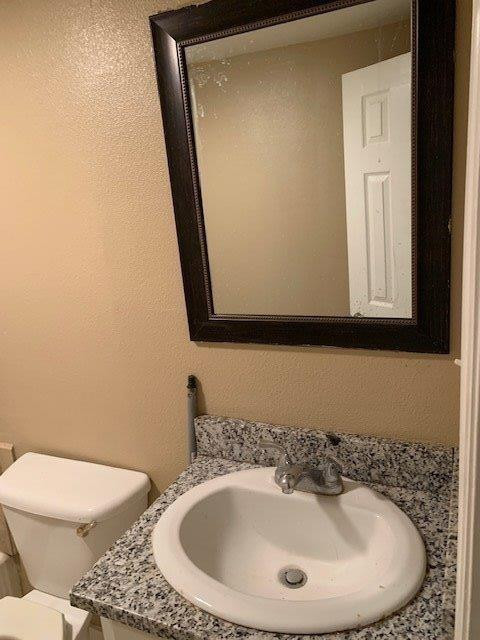 3014 Duke Street Lubbock, TX 79415 - Photo 8 of 10 a bathroom with a toilet sink and mirror