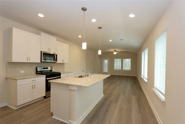 a kitchen with a sink stainless steel appliances and window