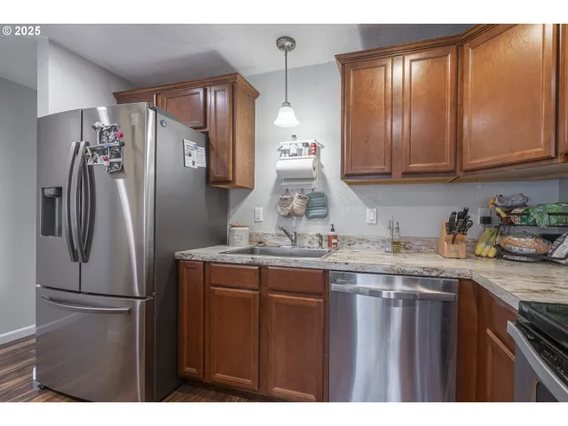 a kitchen with stainless steel appliances granite countertop a refrigerator and a sink