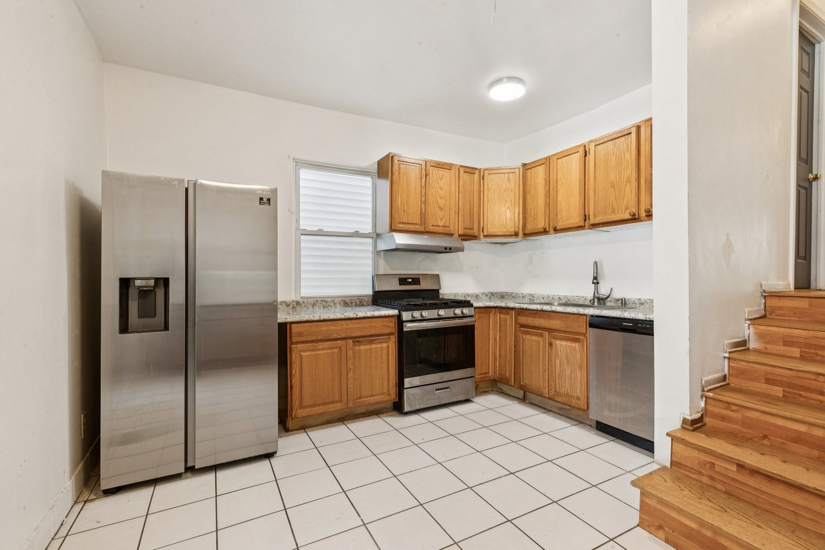 2115 Emerson Street Evanston, IL 60201 - Photo 7 of 37 a kitchen with stainless steel appliances granite countertop a refrigerator a stove and a sink with cabinets