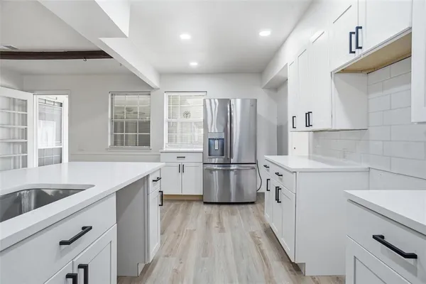 a kitchen with a sink a counter top space stainless steel appliances and cabinets