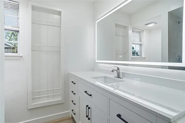 a bathroom with a granite countertop sink and a mirror
