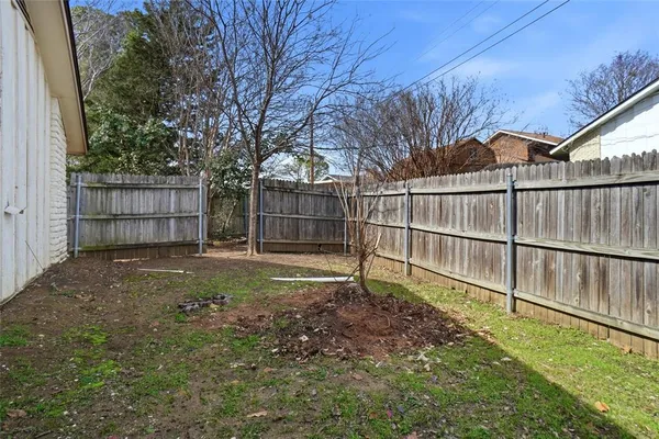 a view of backyard with wooden fence