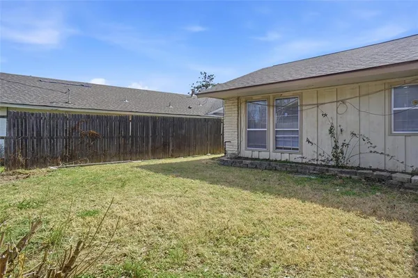 a backyard of a house with table and chairs