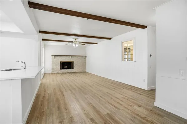 a view of empty room with wooden floor and fireplace