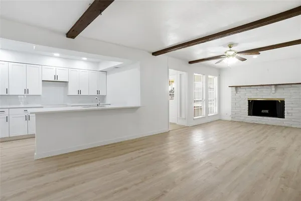a view of large kitchen with granite countertop stainless steel appliances stove top oven and cabinets