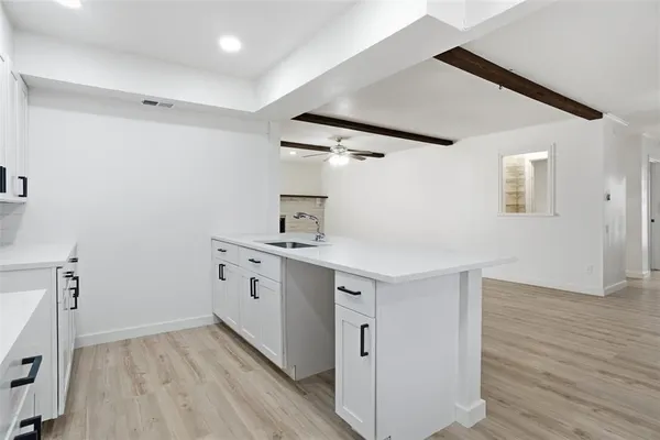 a kitchen with sink cabinets and wooden floor