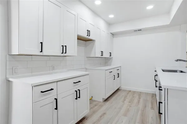 a kitchen with white cabinets and white appliances
